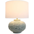 Harbour Seafoam Table Lamp illuminated, showing its textured ceramic base and warm ambient lighting.