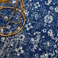 Harley Navy Rug styled beneath a gold side table, showcasing its richly textured navy distressed design.