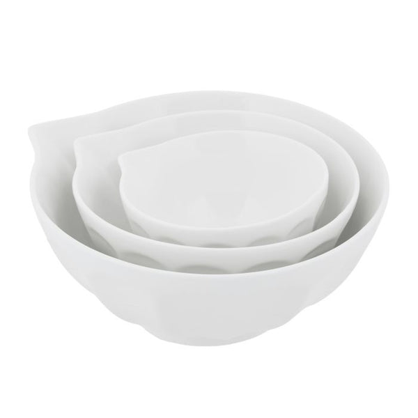 Set of three white porcelain mixing bowls with ridged detailing and pouring lip in coordinating nesting sizes.