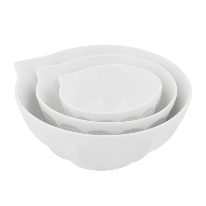 Set of three white porcelain mixing bowls with ridged detailing and pouring lip in coordinating nesting sizes.
