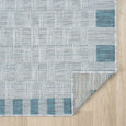 Close-up of Haven Blue Outdoor Rug showing textured grey weave and coastal blue border and  underneath of rug