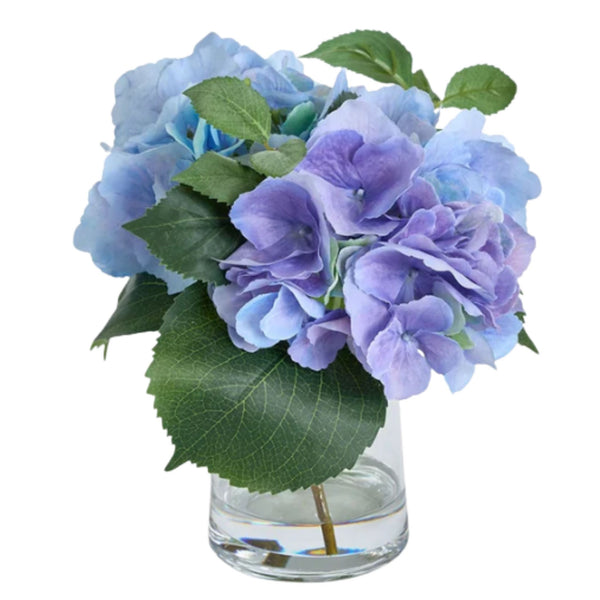 Artificial lavender and blue hydrangea arrangement in a clear glass vase with realistic faux water for Hamptons and coastal home styling.
