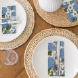 Hydrangea Garden Lunch Napkins styled with white dinner plates, natural woven placemats and silver cutlery for an elegant blue and white Hamptons table setting.