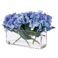 Blue faux hydrangea arrangement styled in a clear rectangular glass trough vase.