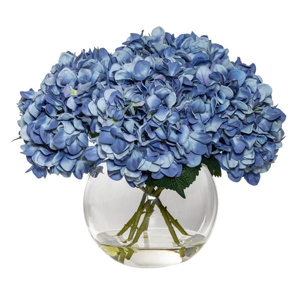 Blue faux hydrangea arrangement displayed in a clear glass Phoebe sphere vase.