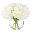 White everlasting hydrangea arrangement in a clear Phoebe Sphere glass vase with lifelike green stems and faux water.
