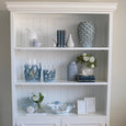 Hamptons-style white bookcase styled with ceramic bird sculpture, blue décor accents and coastal decorative accessories.
