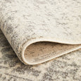 Folded detail of the Isla White Silver Rug showing the flexible backing and textured finish