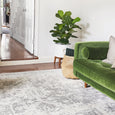 Isla White Silver Rug styled in a contemporary living room with timber flooring and green velvet sofa