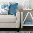 Knightsbridge linen sofa styled with blue cushions beside a white and timber Hamptons side table.