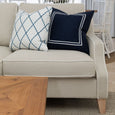 Knightsbridge linen sofa styled with navy and blue patterned cushions in a bright Hamptons interior.