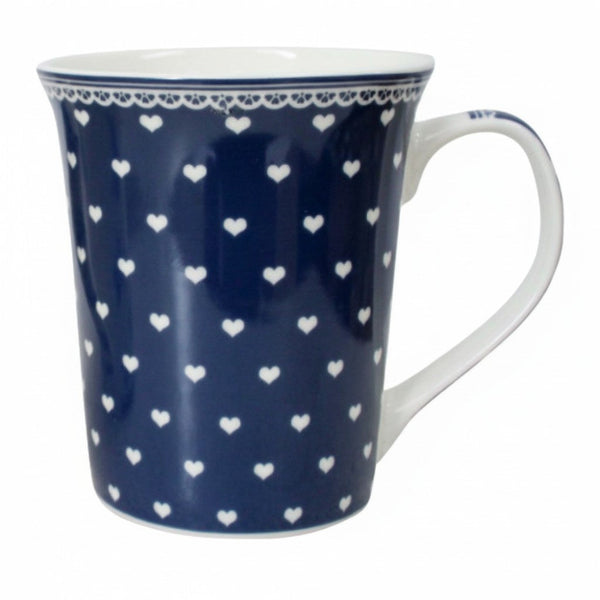 A tall ceramic mug with a navy blue body covered in a repeating pattern of small white hearts. The rim is decorated with a thin white lace-like pattern, and the handle and interior are solid white.