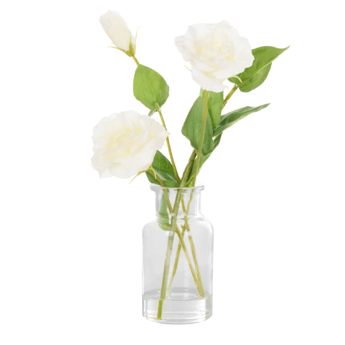White faux lisianthus floral arrangement styled in a clear specimen glass vase with realistic faux water detailing.