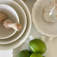 White porcelain mixing bowl set styled on a marble kitchen bench with limes for relaxed coastal kitchen styling.
