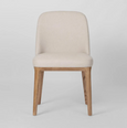 Beige upholstered dining chair with curved backrest and solid ashwood legs