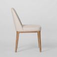 Beige upholstered dining chair with curved backrest and solid ashwood legs