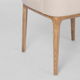 Beige upholstered dining chair with curved backrest and solid ashwood legs