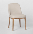 Beige upholstered dining chair with curved backrest and solid ashwood legs