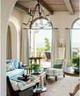 elegant coastal seating area with blue armchairs, chandelier and ocean view from Beautiful by Mark D Sikes