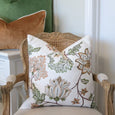 embroidered olive cushion styled on classic armchair with layered green and caramel cushions