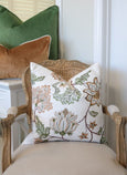 embroidered olive cushion styled on classic armchair with layered green and caramel cushions