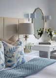 antique silver pineapple table lamp styled on bedside table with blue and white bedding and coastal decor