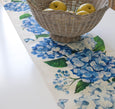Montauk hydrangea table runner with blue floral design styled under woven basket, Hamptons coastal table setting