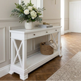 White Nantucket 3 Drawer Hall Table styled in a classic Hamptons hallway with flowers, books and woven basket.