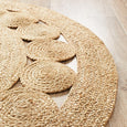 Braided border and circular detailing on natural jute round rug