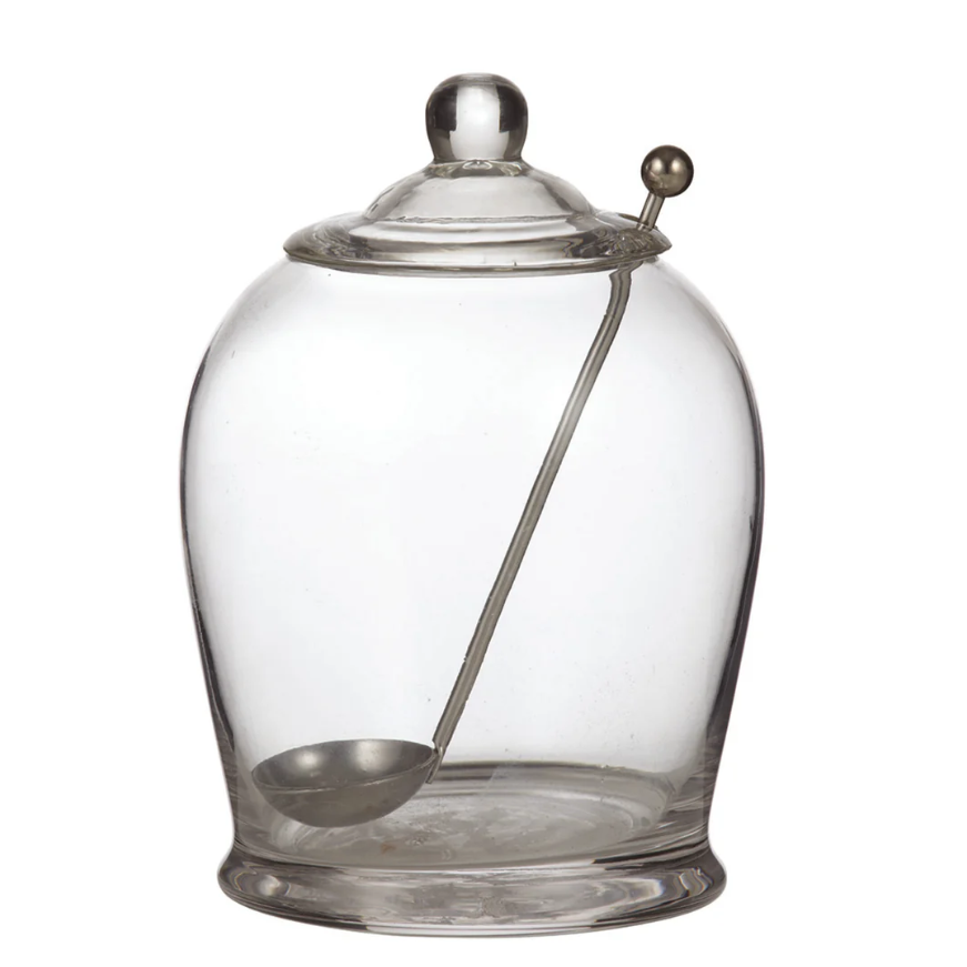 Clear glass olive jar with matching lid and stainless steel serving spoon for stylish entertaining and antipasto presentation