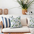 Blue Hydrangea and Blue Stripe outdoor cushions styled on white rattan seating in a relaxed Hamptons coastal outdoor living area.