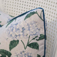 Outdoor Hydrangea Cushion Blue 45x45cm with blue hydrangea floral print, green leaves, cream background and blue piping showing corner detail