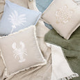 Coastal styled cushions featuring palm, lobster and turtle embroidery in soft neutral and chambray tones