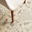 Parker White Rug styled beneath a linen chair showcasing the soft distressed floral design