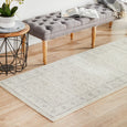 Parker Winter White Runner Rug styled beside a tufted bench with neutral décor and white orchids.