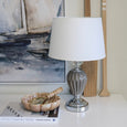 Parkes table lamp with white shade styled on console with coastal artwork and decor
