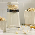 Peggy large stoneware popcorn bowl styled beside a cream popcorn maker and filled with freshly popped popcorn