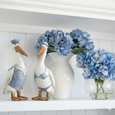 Pelicans Set of 2 styled on white shelving with blue hydrangeas and white ceramic vases in a Hamptons interior.