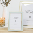 White and gold Portofino photo frame styled on a console table beside a candle and ceramic vase in a coastal-inspired interior.