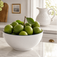 White stoneware bowl styled on a coastal kitchen bench with fresh limes and classic décor accents