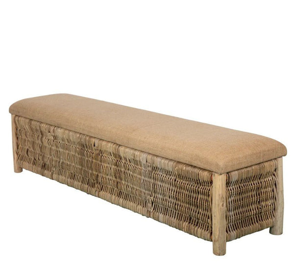 Wicker storage bench with cushioned seat styled at end of bed in neutral coastal bedroom