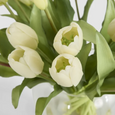 Close-up of realistic white Real Touch tulip flowers and lifelike green foliage