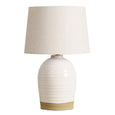 Rimmel table lamp featuring a ridged white ceramic base with matte gold accent and neutral fabric shade.