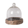 glass cloche with woven willow base on neutral background