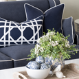 Riviera Navy Rectangle Cushion with white lattice detail layered with navy cushions in a blue and white Hamptons living room.
