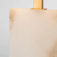 Modern alabaster and brass table lamp styled on a home office desk with soft diffused lighting