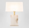 Elegant Roco table lamp creating warm ambient lighting in a modern bedroom interior