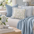 Rodeo Baby Blue Cushion Cover 60cm styled with blue striped and floral ruffle cushions and a soft blue throw in a Hamptons coastal living room.