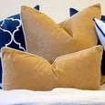 Rodeo Caramel velvet cushions layered with navy and white cushions on a Hamptons style bed