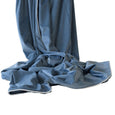 Ocean blue velvet throw with white piping draped softly, showcasing smooth texture and luxurious finish